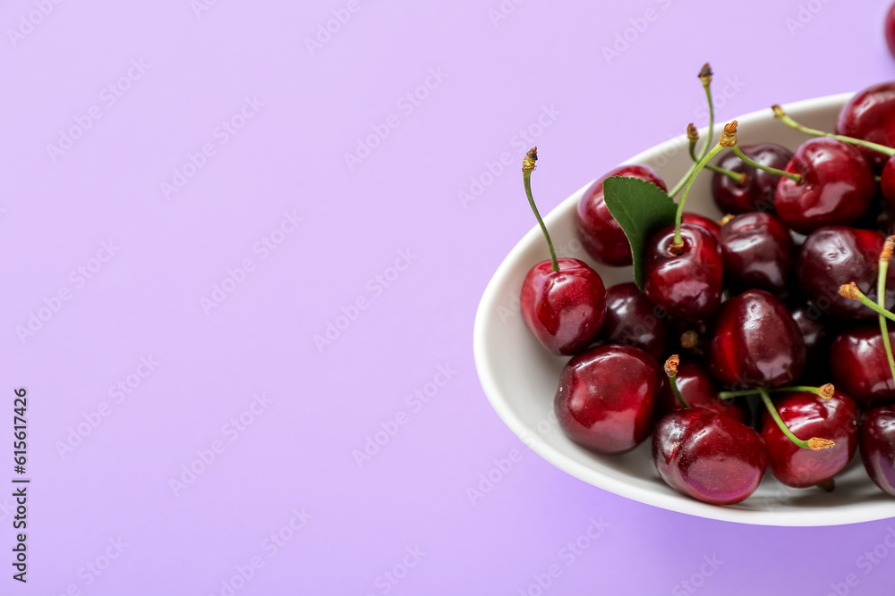 Bowl with sweet cherries on lilac background Bowl with sweet cherries on lilac background