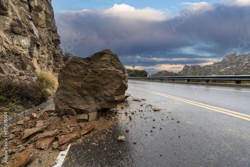 Rainy road rockslide blocki...