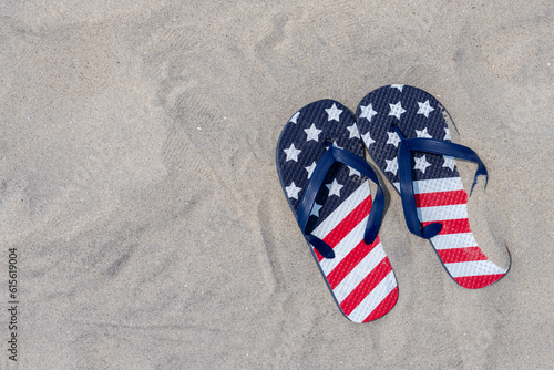 vacation concept with patriotic red white and blue flip flops on the beach
