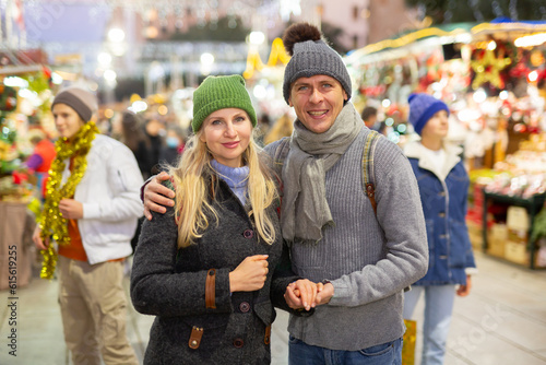 Portrait of a happy european married couple who came on the eve of the holidays at the Christmas fair © JackF