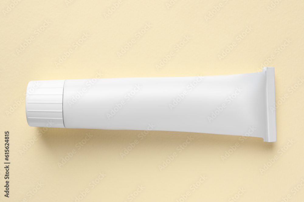 Tube of ointment on beige background, top view. Space for text Tube of ointment on beige background, top view. Space for text
