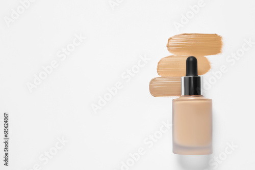 Liquid foundation and swatches on white background, top view. Space for text