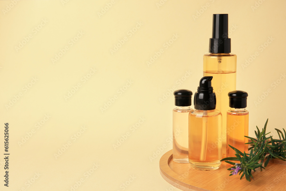 Bottles with cosmetic products and rosemary on beige background. Space for text
