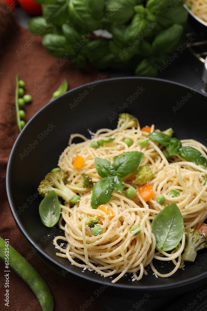 Delicious pasta primavera with basil, broccoli and peas on table, closeup
