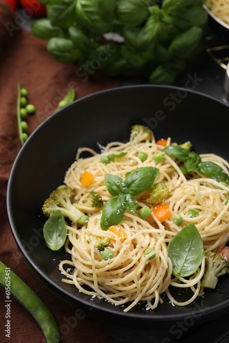 Delicious pasta primavera with basil, broccoli and peas on table, closeup