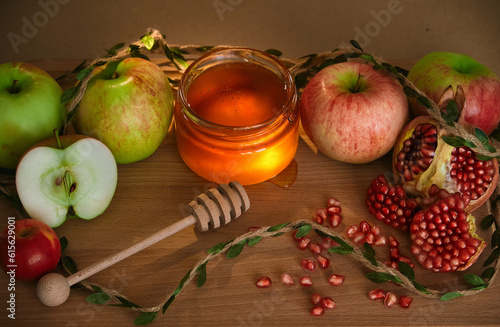 Traditional Jewish new year food card. Red and green apples, pomegranate and honey on wooden background. Happy Rosh Hashanah concept.