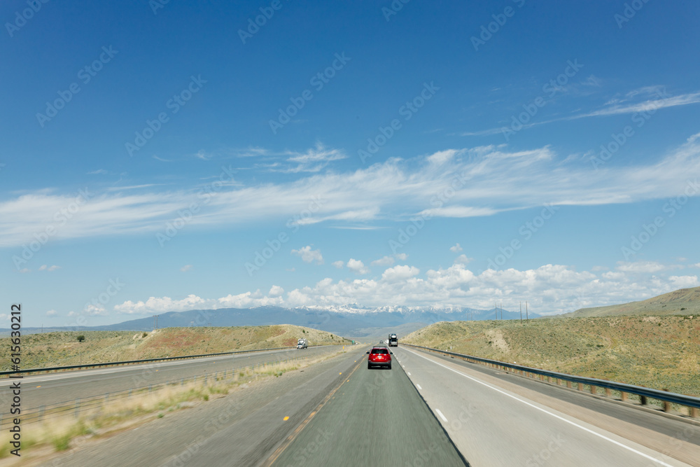 Fototapeta premium Beautiful road on a sunny day. Highway in America among the mountains. Traveling on a beautiful road. Holiday trip
