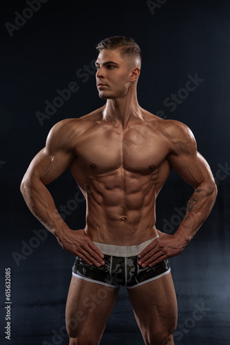 Bodybuilder showing off his perfect low fat body without clothes in studio © Vitalii But