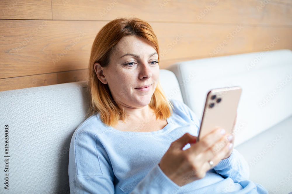 Mid adult woman using a smart phone at home Mid adult woman using a smart phone at home