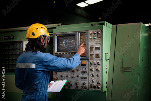 Engineer worker wearing safety uniform control operating and check controlled Lathe grinding machine working in industry factory is industry technology concept.