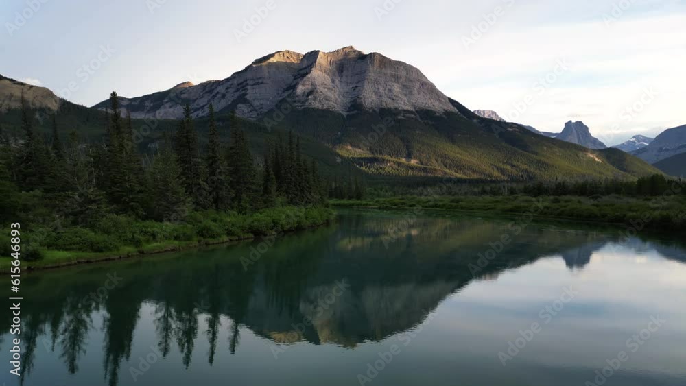 Drone flying over the water, bow river, Mountain view on the sunset, reflection on the bow river, Banff National park Drone flying over the water, bow river, Mountain view on the sunset, reflection on the bow river, Banff National park
