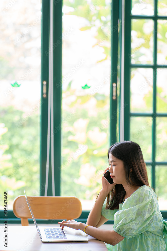 Busines female using her laptop at a cafe sitting at a table with a cup of coffee Busines female using her laptop at a cafe sitting at a table with a cup of coffee