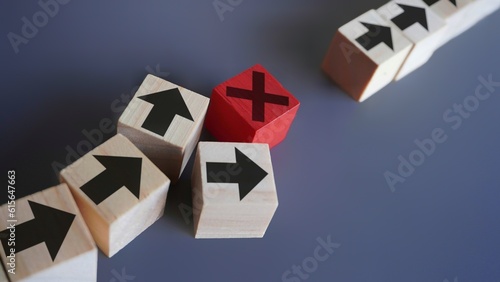 Wooden blocks with arrow and error icon. Delays and disruptions, stop the process, critical error concept photo