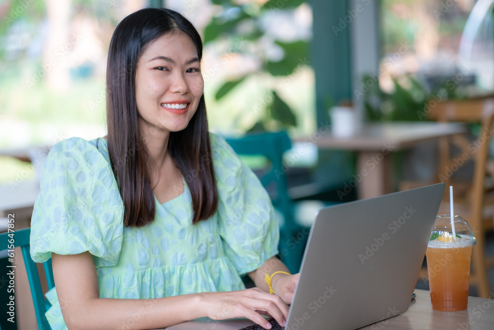 Busines female using her laptop at a cafe sitting at a table with a cup of coffee Busines female using her laptop at a cafe sitting at a table with a cup of coffee