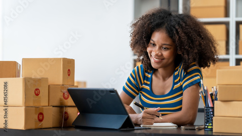 Pretty young african american woman startup freelancer business people is working at warehouse for online store. © makibestphoto