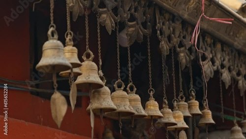 Row of hanging brass wind bells outside temple in Kathmandu, Nepal photo