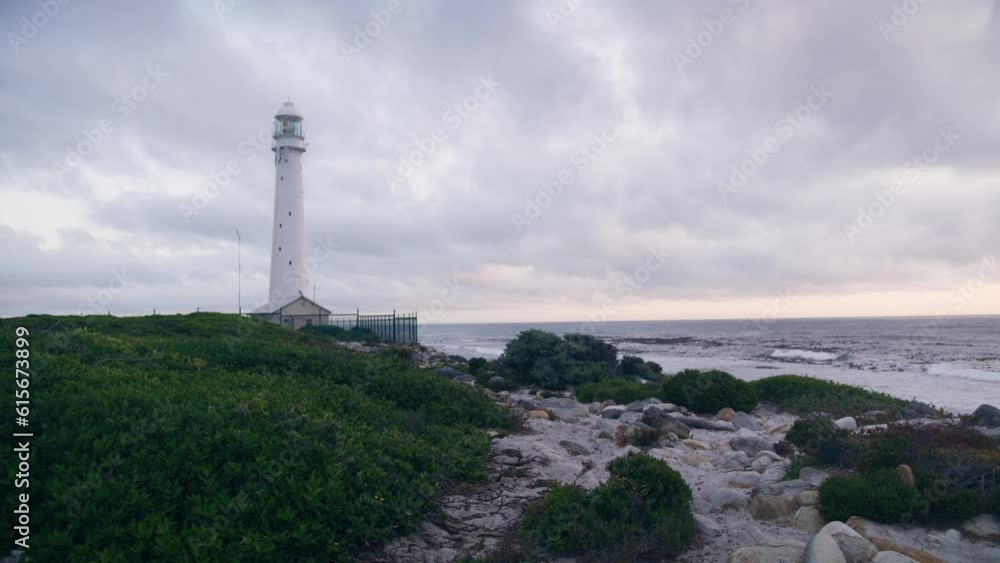Slangkop lighthouse in Kommetjie at blue hour with ocean in background at the beach Slangkop lighthouse in Kommetjie at blue hour with ocean in background at the beach