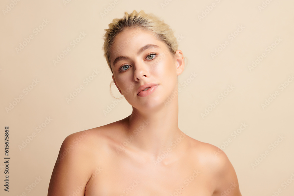 Fototapeta premium Beautiful young woman with clean fresh skin on beige background, Face care, Facial treatment, Cosmetology, beauty and spa, women portrait.