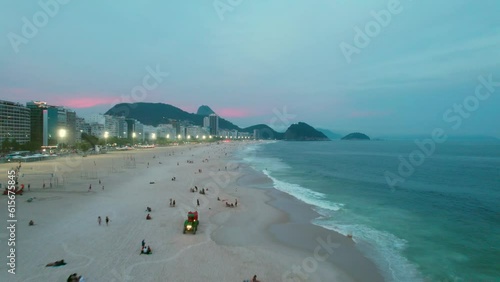 Drone flying low over iconic Copacabana beach during dusk lights, Rio de Janerio photo