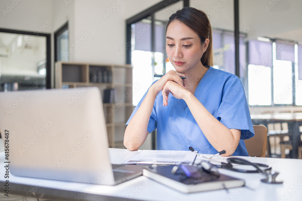 Happy doctor Portrait of young asian woman nurse or doctor smiling using a laptop writing content at consultation Happy doctor Portrait of young asian woman nurse or doctor smiling using a laptop writing content at consultation