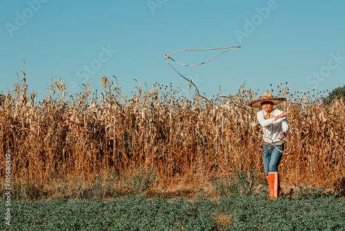 A cowboy in the expansive prairie, wielding his lariat amidst a bountiful harvest