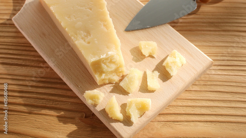 Foto Hard cheese with a knife on a cutting board