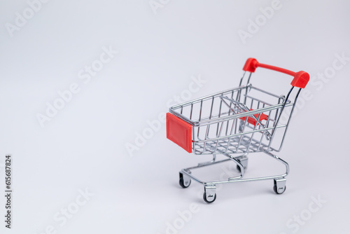 Close up red supermarket cart on white background. Online shopping, e-commerce, spending money concept. Shopping service on The online web. offers home delivery. free space for advertising