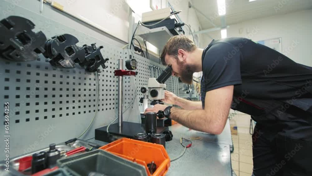 Diagnostics of diesel injectors under a microscope. The master examines the nozzle under a microscope to detect defects. Diagnostics of diesel injectors under a microscope. The master examines the nozzle under a microscope to detect defects.