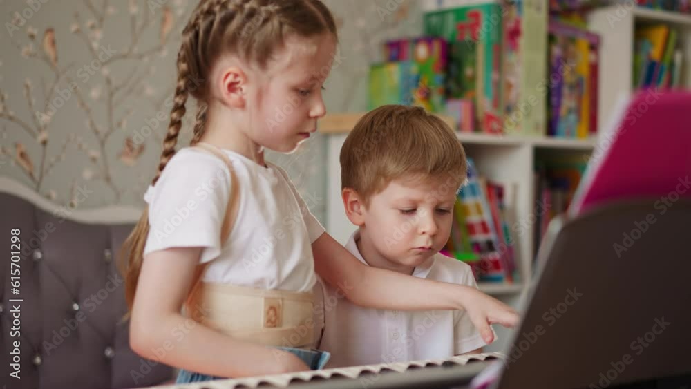 Toddler kid sighs while elder sister shows boring musical chords in children room. Demotivated little boy looks at girl with corsage playing music Toddler kid sighs while elder sister shows boring musical chords in children room. Demotivated little boy looks at girl with corsage playing music