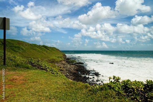 Beautiful seascape with majestic white clouds, blue sky and green grass in Kauai, Hawaii, USA