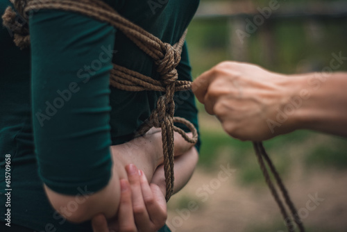 a man ties up a woman in green body and black tights with a natural rope japanese art of aeshetic shibari bandage kinbaku