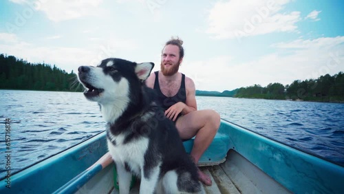 Caucasian Guy Boating With His Alaskan Malamute. POV