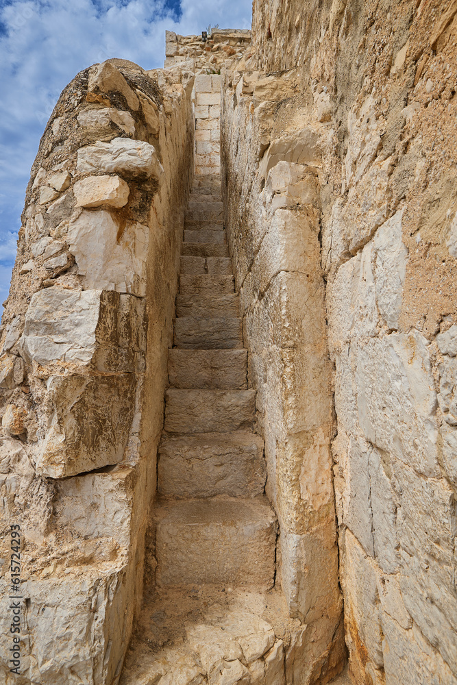 Fototapeta premium Narrow and steep stone staircase in the wall of a medieval castle