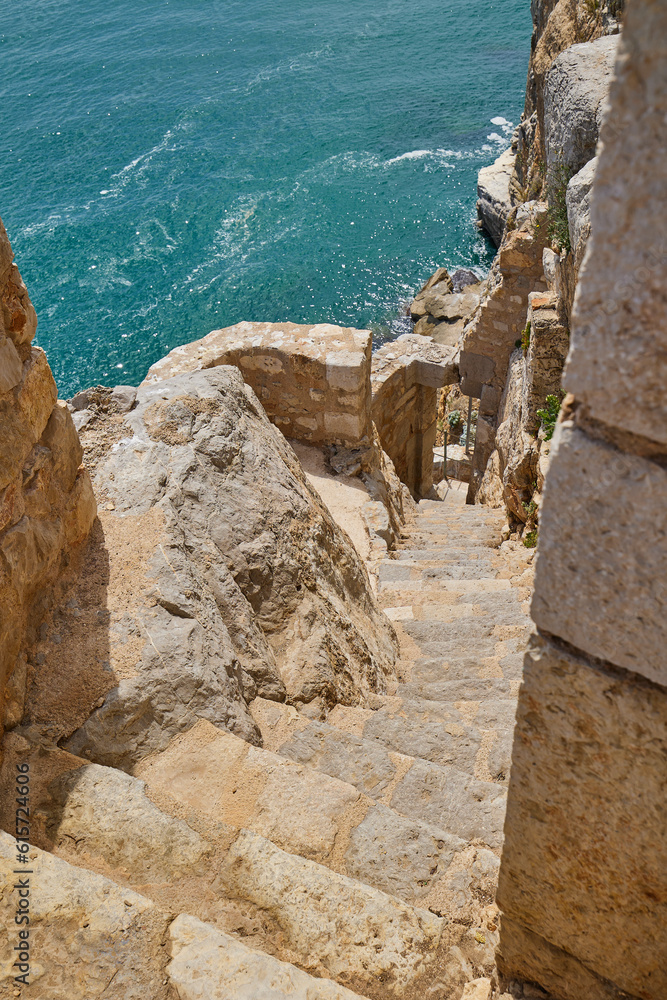 The endless turquoise Mediterranean Sea and the stone stairs leading down from the top of the cliff.