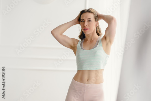 Portrait of young attractive sporty girl working out at home