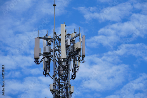 Telecommunication tower of 4G and 5G cellular. Macro Base Station. 5G radio network telecommunication equipment with radio modules and smart antennas mounted on a metal against cloulds sky background.