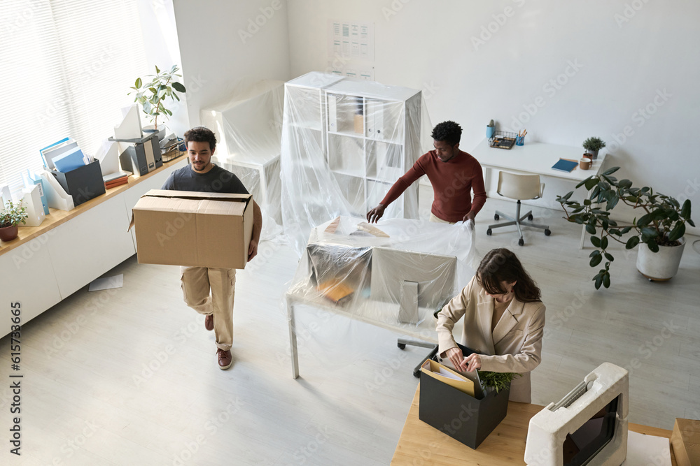 High angle view of business people packing things and furniture while moving in new office High angle view of business people packing things and furniture while moving in new office