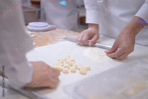 Hands of a young woman in an apron holding a rolling pin on a table. ,Create the dough, baking, baking ideas, homemade bakery. shooting while moving
