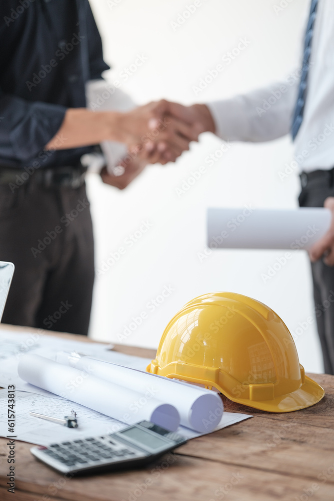 Close-up image of an engineer shaking hands with his coworker during the meeting. teamwork, building trust, unity Close-up image of an engineer shaking hands with his coworker during the meeting. teamwork, building trust, unity