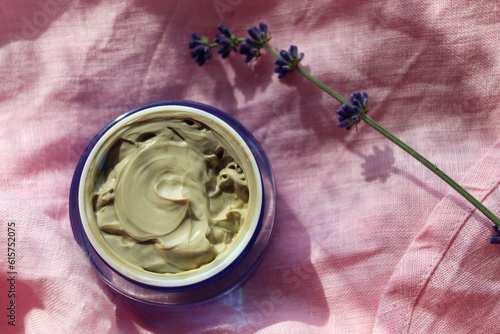 jar with cream on pink linen fabric