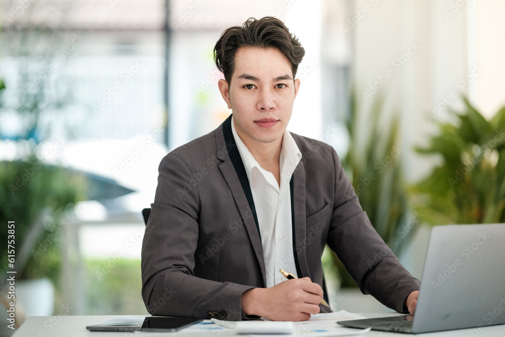 Portrait of businessman sitting at office desk, looking at camera. Portrait of businessman sitting at office desk, looking at camera.