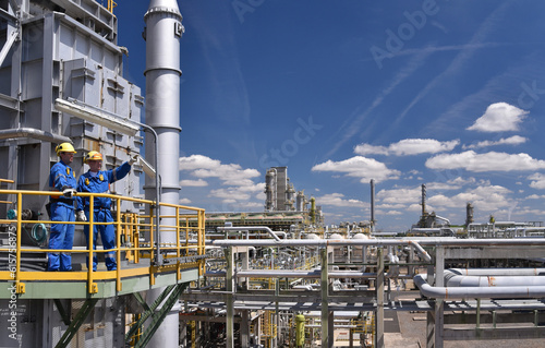 group of workers professional equipment in a petroleum refinery - modern buildings and industrial facilities for the production of fuel and gas