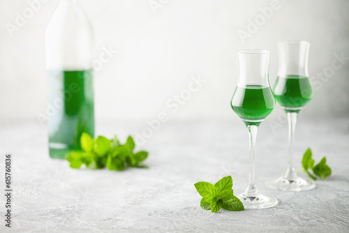Delicious mint liqueur with green leaves on the table. Copy space