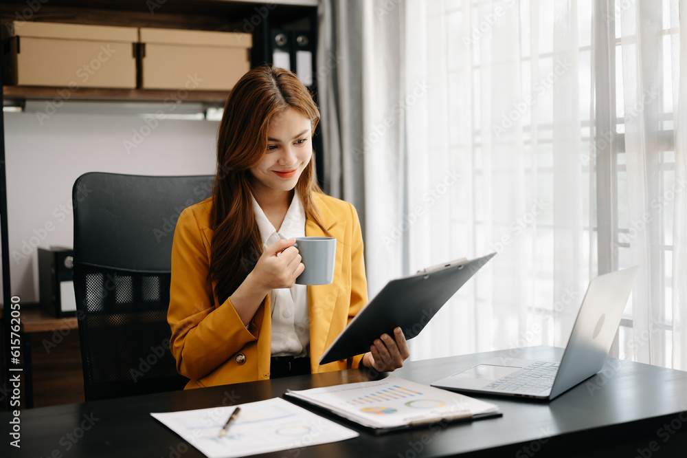 Asian businesswoman working in the office with working notepad, tablet and laptop documents Asian businesswoman working in the office with working notepad, tablet and laptop documents