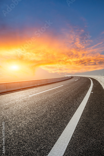 Asphalt road and colorful sky clouds at sunset