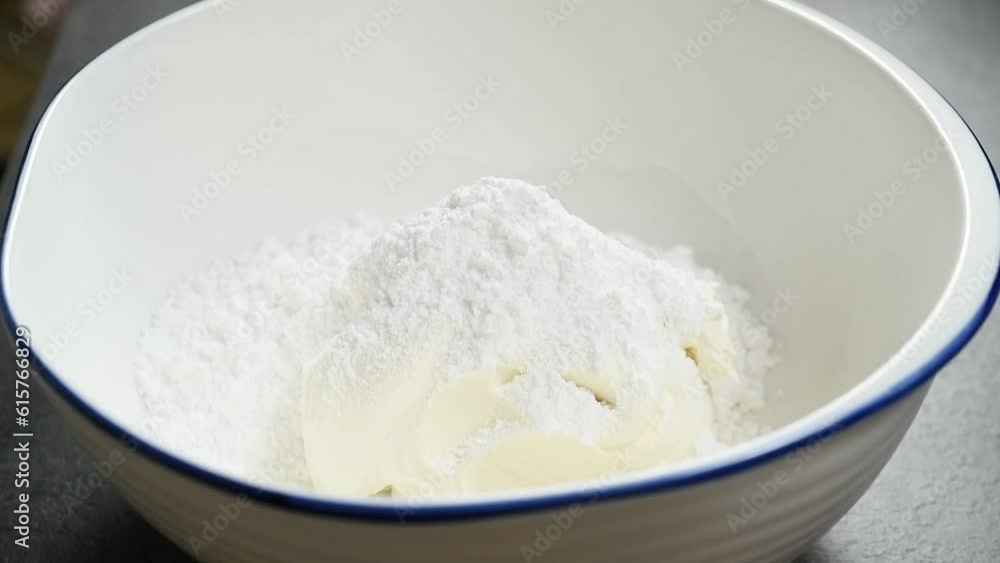 Adding powdered sugar to the mascarpone in the bowl.
Adding powdered sugar to the mascarpone in the bowl.