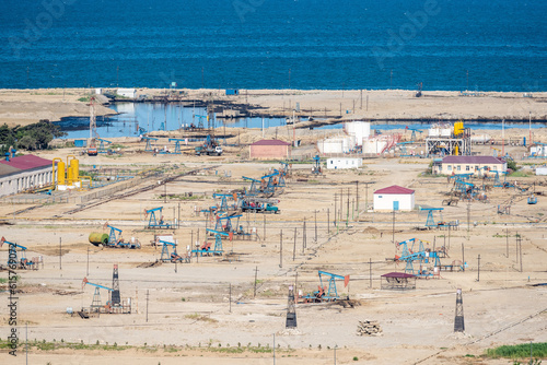 Onshore oil field with derrick pumps on the Caspian coast in Azerbaijan.