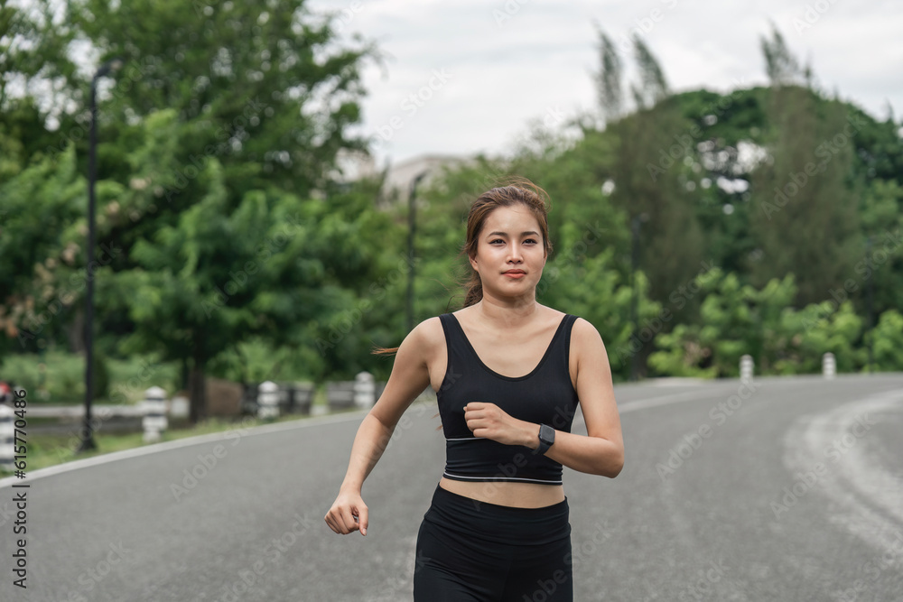 Jogging woman running in park on beautiful day off. Sport fitness model of asian ethnicity training outdoor for marathon Jogging woman running in park on beautiful day off. Sport fitness model of asian ethnicity training outdoor for marathon