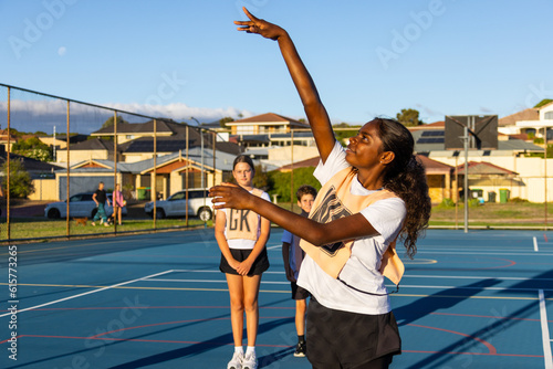 aboriginal girl shooting goal in netball team photo