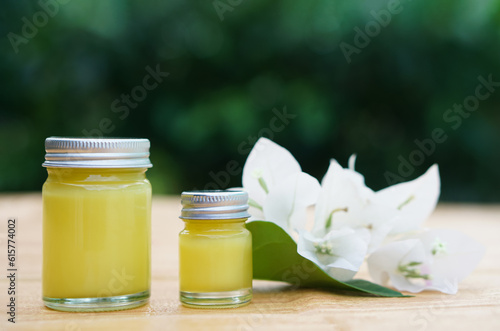 Bottles of homemade Thai herbal ointment.Decorated with white flowers.Concept, Thai local wisdom to use  fragrant medicinal herbs to make inhaler and massage balm.                        